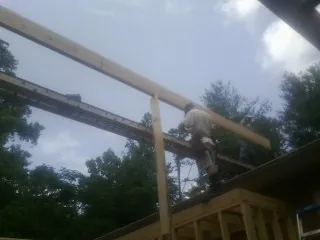 Carpenter setting a ridge beam over a new addition frame — Ice Dam Removal by Roofing Brothers in Bay Shore