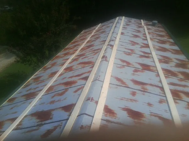 Rusted metal roof panels with new wood purlins before replacement — Storm Damage Roof Repair in Bay Shore by Roofing Brothers