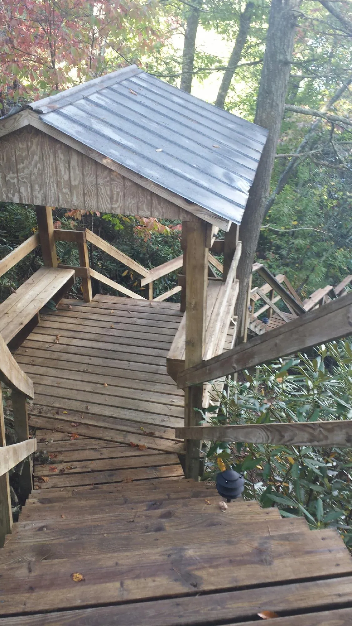 Metal roofed shelter over wooden steps on a wooded walkway — Skylight Repair & Installation work by our crew in Bay Shore