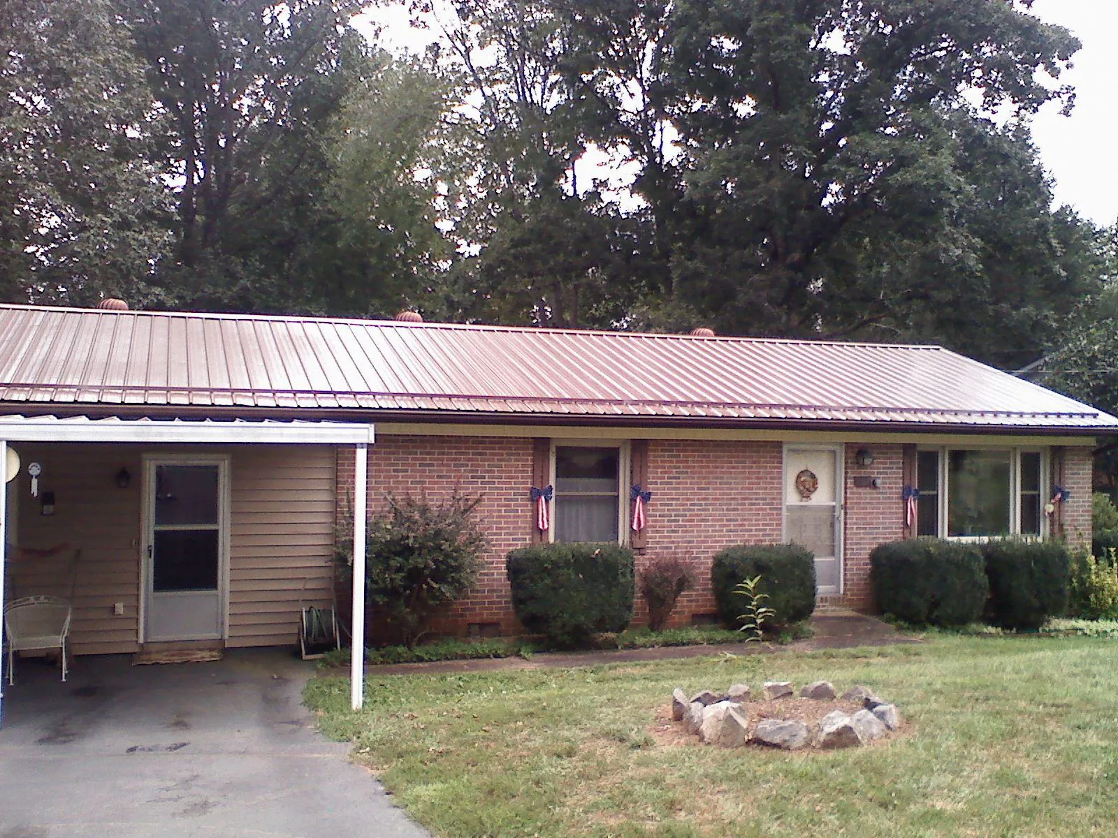 Bronze metal roof and carport on a brick ranch home — Roof Repair work by our crew in Bay Shore