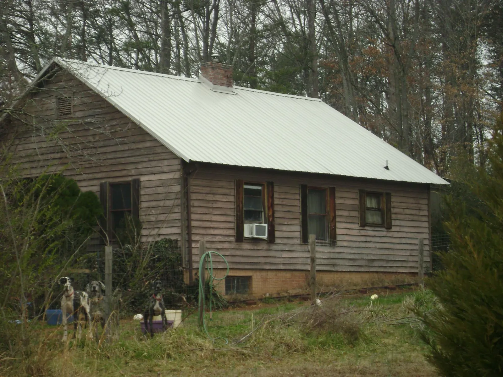 White metal roof on an old wood sided farmhouse, from a Metal Roof Installation job in Bay Shore